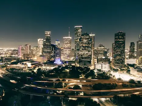 Stunning aerial view of Houston's illuminated skyline featuring skyscrapers and highways at night.